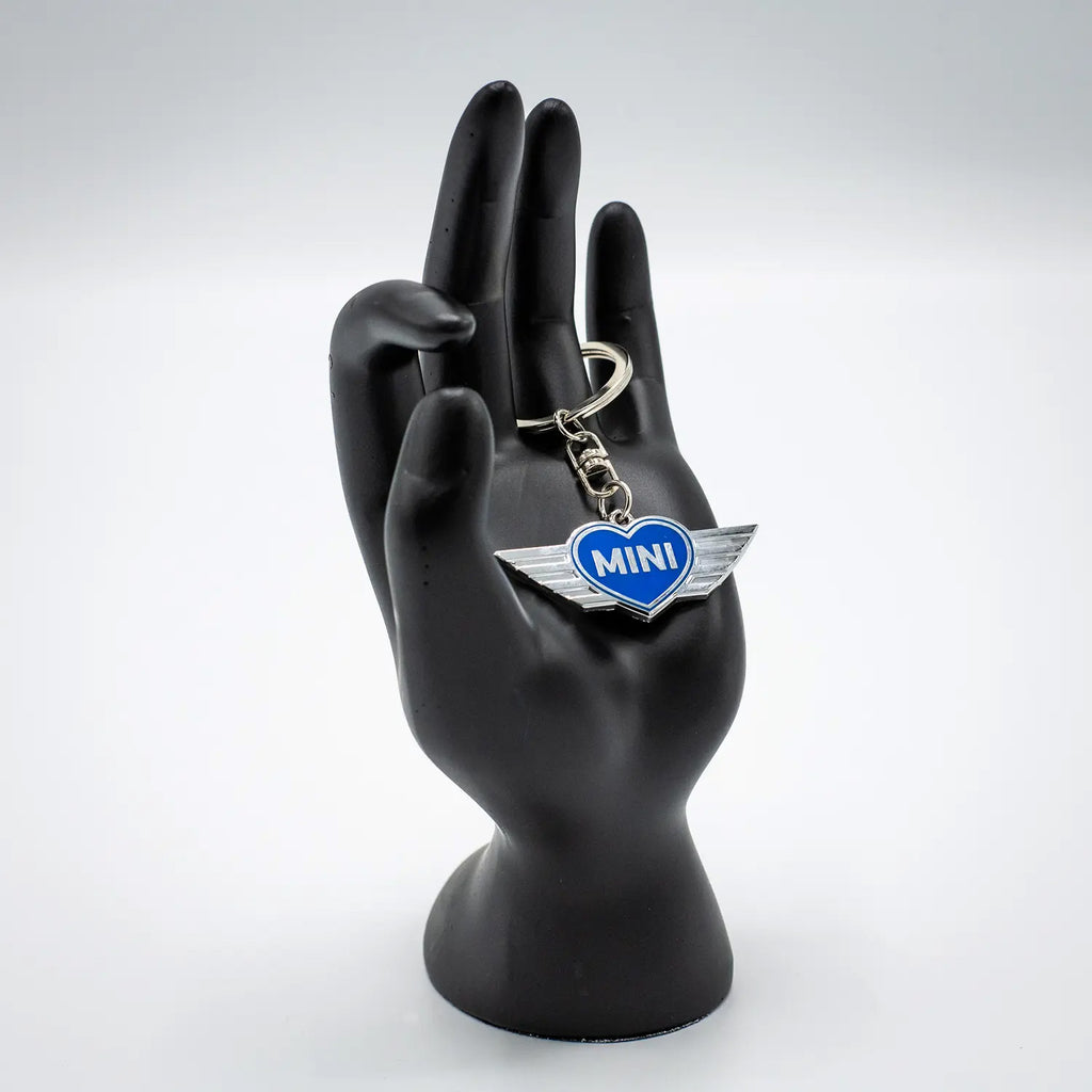 Keychain with an Electric Blue MINI heart design on a black mannequin hand against a white background.