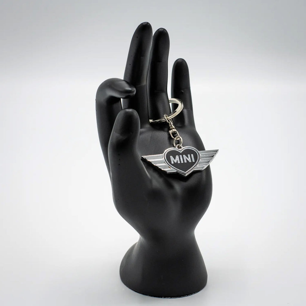 Keychain with a Jet Black MINI heart design on a black mannequin hand against a white background.
