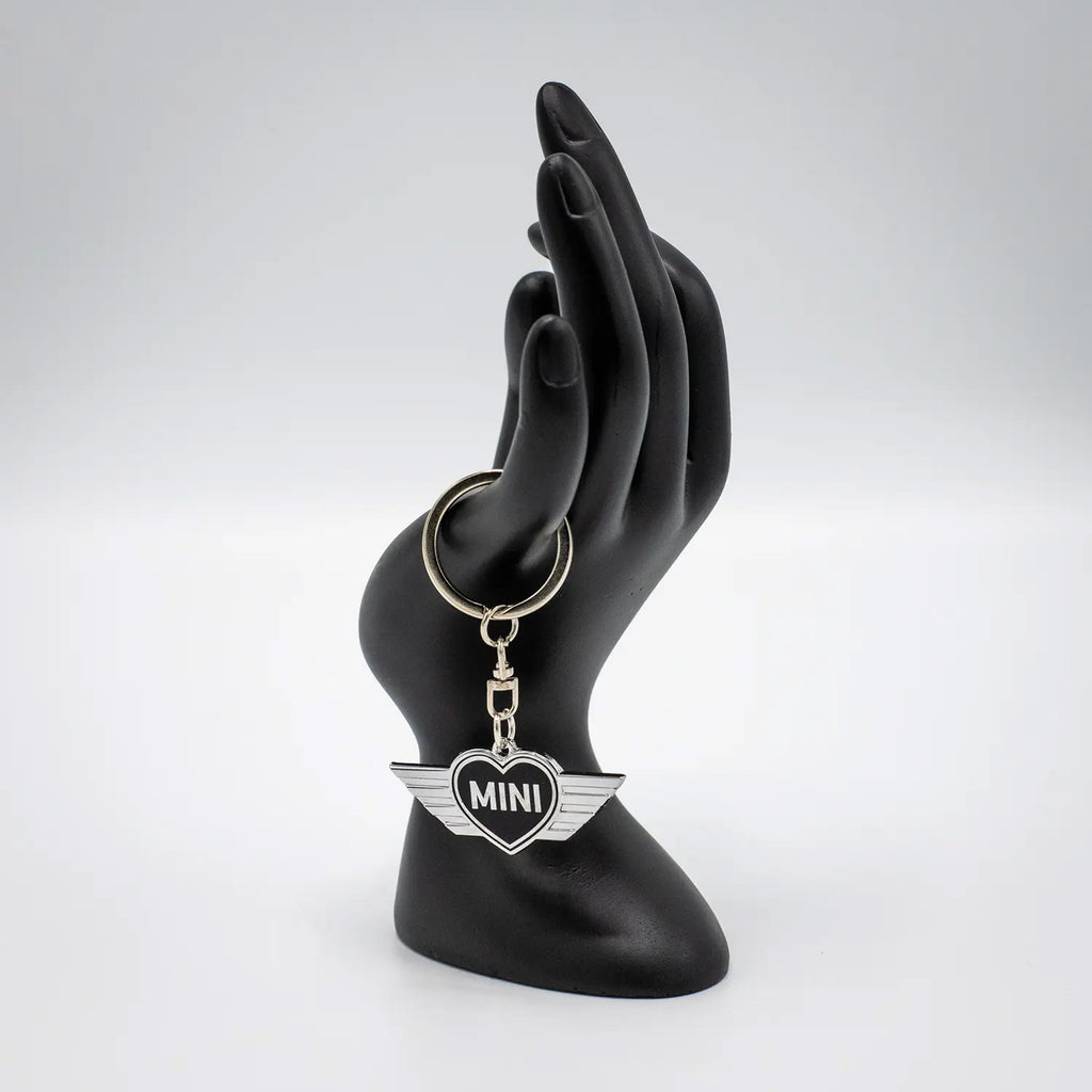 Keychain with a Jet Black MINI heart design on a black mannequin hand against a white background.