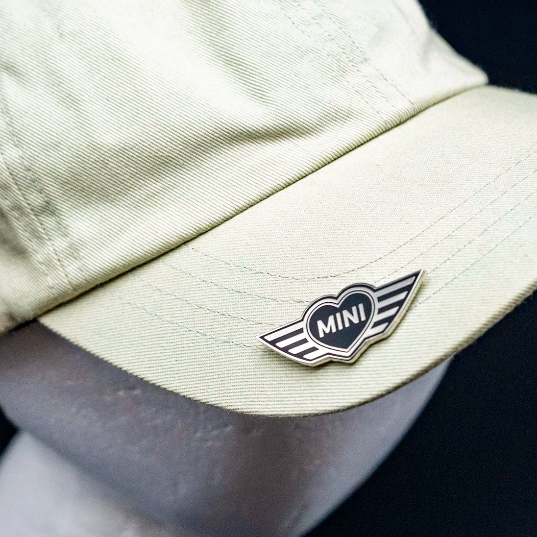 Close-up of a MINI Heart pin on a cap.