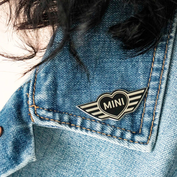 Close-up of a MINI Heart pin on a jean jacket lapel.