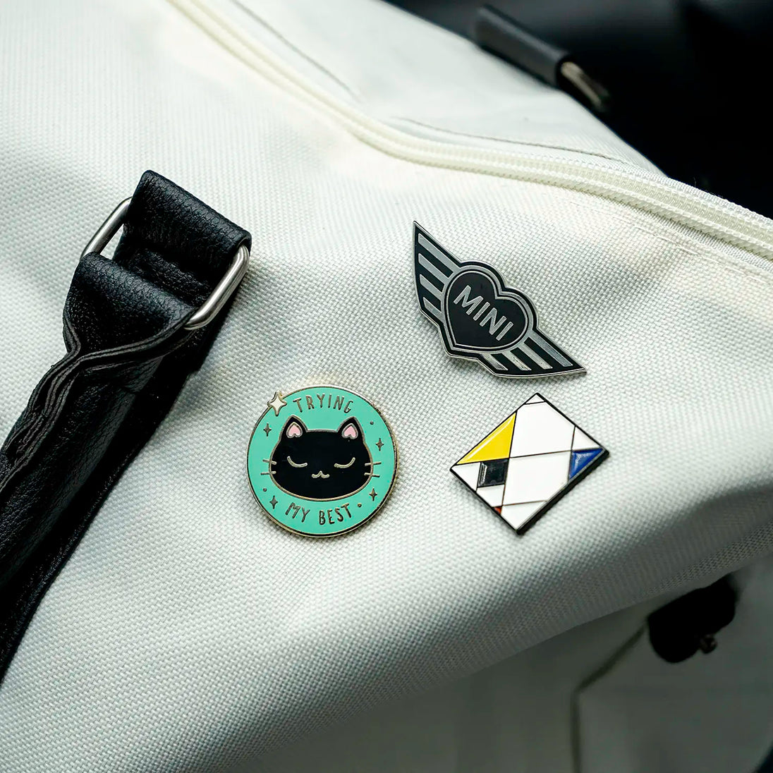 Close-up of a purse with several pins, including the MINI Heart pin.