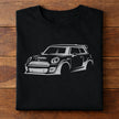 Black t-shirt with a white r53 MINI Cooper GP gesture sketch laying on a wooden surface.