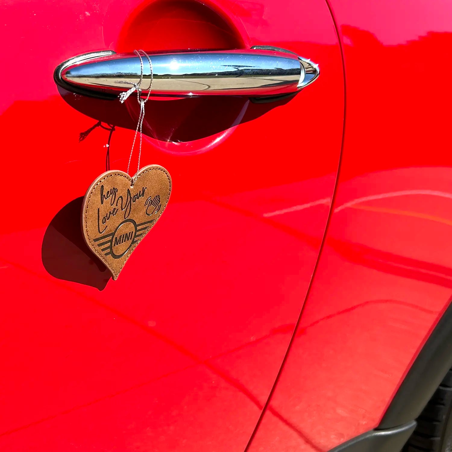 MINI Love Ducking Ornament hanging from a red MINI door handle.