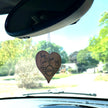 MINI Love Ducking Ornament hanging from a MINI's rearview mirror with a scenic background.